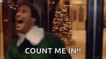 A Man In A Green Sweater Is Laughing And Saying `` Count Me In ! '' In Front Of A Christmas Tree . GIF