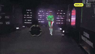 A Man In A Green T Shirt Holds A Red And White Flag GIF