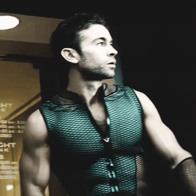 A Man In A Green Vest Stands In Front Of A Sign That Says Night Park GIF