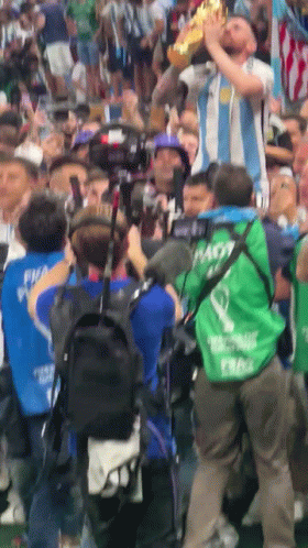 A Man In A Green Vest With The Word Nasty On It Holds A Trophy GIF