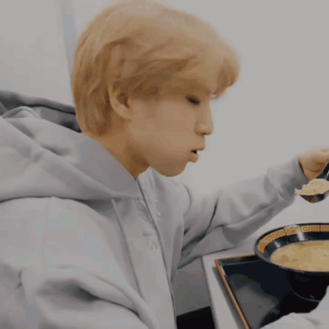Man Eating From Bowl In Grey Hoodie GIF