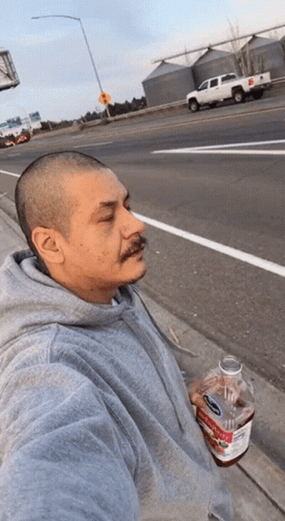 A Man In A Grey Hoodie Is Holding A Bottle Of Apple Cider Vinegar .. GIF