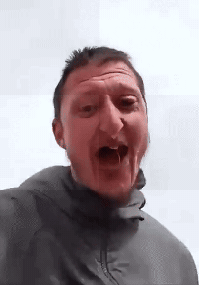 A Man In A Grey Jacket Is Making A Funny Face . GIF