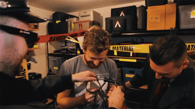 A Man In A Grey Shirt Is Being Measured By A Man In A Black Suit GIF