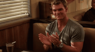 A Man In A Grey Shirt Is Clapping His Hands In A Diner . GIF