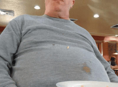 A Man In A Grey Shirt Is Holding A Plate GIF