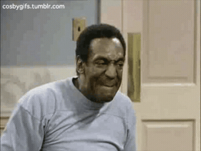 A Man In A Grey Shirt Is Making A Funny Face . GIF