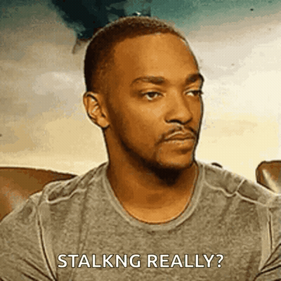 A Man In A Grey Shirt Is Sitting On A Couch And Asking If He Is Talking Really . GIF