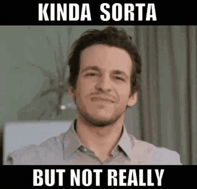 A Man In A Grey Shirt Is Smiling And Making A Funny Face . GIF