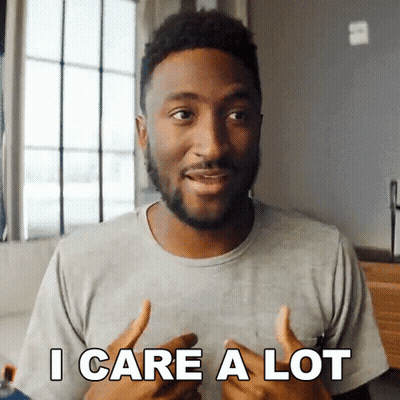 A Man In A Grey Shirt Says " I Care A Lot " In Front Of A Window GIF