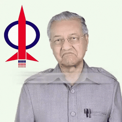 A Man In A Grey Suit Is Standing In Front Of A Rocket With The Letter P On It GIF