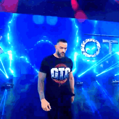 A Man In A Gtc Shirt Stands In Front Of A Blue Background GIF