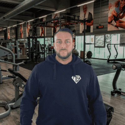 A Man In A Gym Wearing A Hoodie That Says ' Mts ' On It GIF