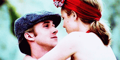 A Man In A Hat And A Woman In A Red Headband Are Hugging GIF