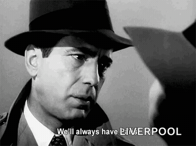 A Man In A Hat And Tie Is Talking To Another Man In A Suit . GIF