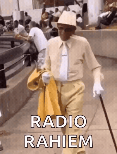 A Man In A Hat And Tie Is Walking Down The Street With A Cane And A Yellow Jacket . GIF