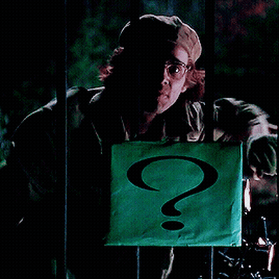 A Man In A Hat Holds A Green Sign With A Question Mark On It GIF