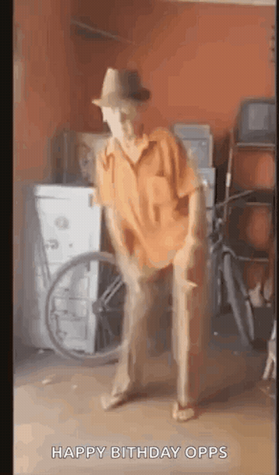 A Man In A Hat Is Dancing In A Garage With A Wheelchair In The Background . GIF