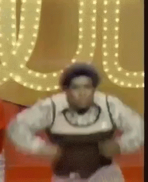 A Man In A Hat Is Dancing In Front Of A Sign That Says ' U ' GIF