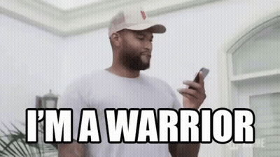 A Man In A Hat Is Holding A Cell Phone And Says `` I 'M A Warrior '' . GIF