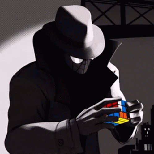 A Man In A Hat Is Holding A Colorful Rubik 'S Cube In His Hands GIF