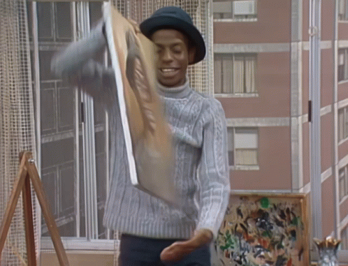 A Man In A Hat Is Holding A Painting That Says ' A ' On It GIF