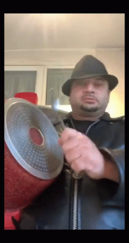 A Man In A Hat Is Holding A Pot GIF