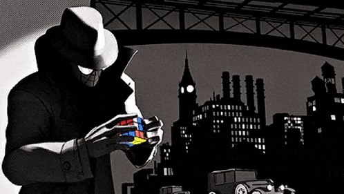 A Man In A Hat Is Holding A Rubik 'S Cube In His Hands . GIF