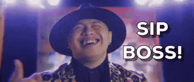 A Man In A Hat Is Laughing And Giving A Thumbs Up While Saying `` Sip Boss '' . GIF