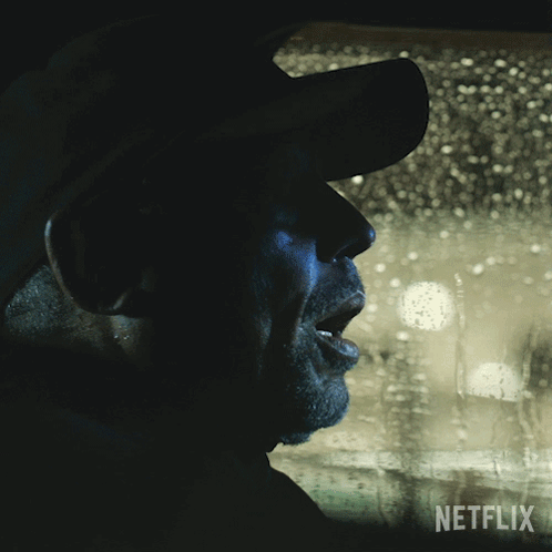 A Man In A Hat Is Looking Out A Window With A Netflix Logo On The Bottom GIF
