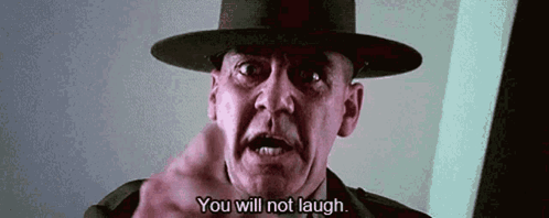 A Man In A Hat Is Pointing At The Camera And Says `` You Will Not Laugh . '' GIF