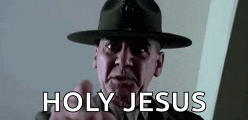 A Man In A Hat Is Pointing At The Camera With The Words `` Holy Jesus '' Written On The Screen . GIF