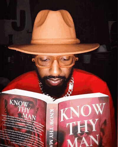 A Man In A Hat Is Reading A Book Titled Know Thy Man GIF