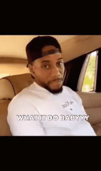 A Man In A Hat Is Sitting In The Back Seat Of A Car And Says `` What It Do Babyyy '' . GIF