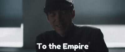 A Man In A Hat Is Smiling And The Words To The Empire Are Behind Him GIF