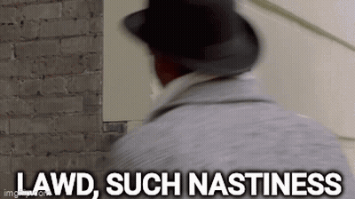 A Man In A Hat Is Standing In Front Of A Brick Wall And Says `` Lawd , Such Nastiness '' . GIF