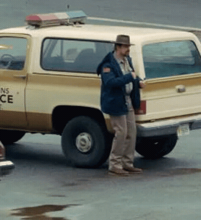 A Man In A Hat Is Standing Next To A Ns Police Truck GIF