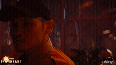 A Man In A Hat Is Standing Next To A Woman In A Disney + Ad GIF