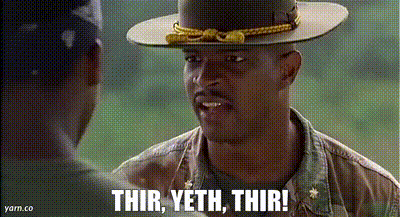 A Man In A Hat Is Talking To Another Man In A Field . GIF