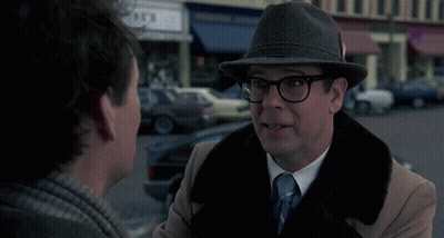 A Man In A Hat Is Talking To Another Man With The Word Bing Behind Him GIF