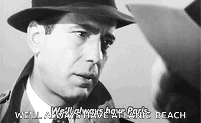 A Man In A Hat Is Talking To Another Man With The Words We 'Ll Always Have Atlantic Beach Below Him GIF