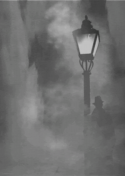 A Man In A Hat Stands In Front Of A Street Light GIF