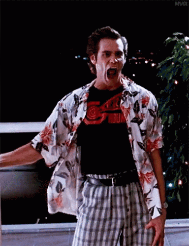 A Man In A Hawaiian Shirt And Plaid Shorts Is Screaming With His Mouth Open . GIF