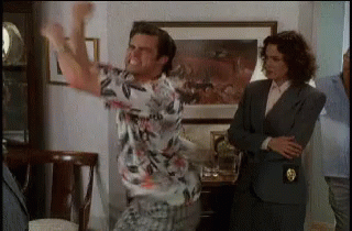 A Man In A Hawaiian Shirt Is Dancing In A Living Room GIF