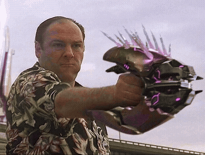 A Man In A Hawaiian Shirt Is Holding A Purple Object With Spikes On It GIF