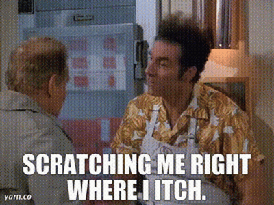 A Man In A Hawaiian Shirt Is Scratching Another Man In A Kitchen GIF