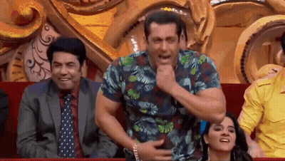 A Man In A Hawaiian Shirt Is Sitting In A Theatre With Other People And Making A Funny Face . GIF
