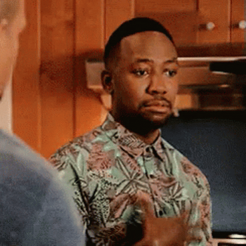 A Man In A Hawaiian Shirt Is Standing In A Kitchen Talking To Another Man . GIF