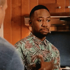 A Man In A Hawaiian Shirt Is Standing In A Kitchen Talking To Another Man . GIF