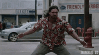 A Man In A Hawaiian Shirt Is Standing In Front Of A Friendly Market GIF